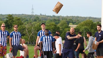 Ein Mitarbeiter von Sonotronic wirft einen Baumklotz, bei den Highländle Games