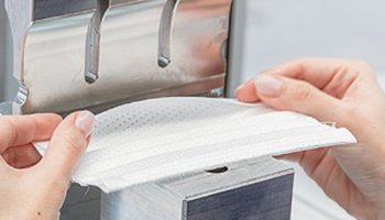 Manuelles Umlegen der Vlieskante vor dem Ultraschall-Schweißen.