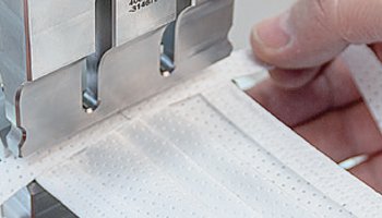 Vlies-Flachbänder, die zur Befestigung am Kopf dienen, auf der kurzen Seite auflegen